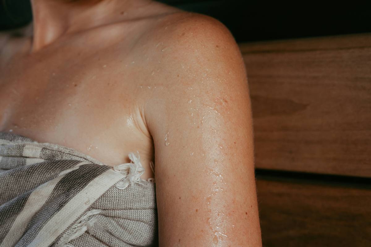 Diagram comparing how body oil forms a continuous lipid layer on skin vs. lotion's water-based formula that evaporates quickly