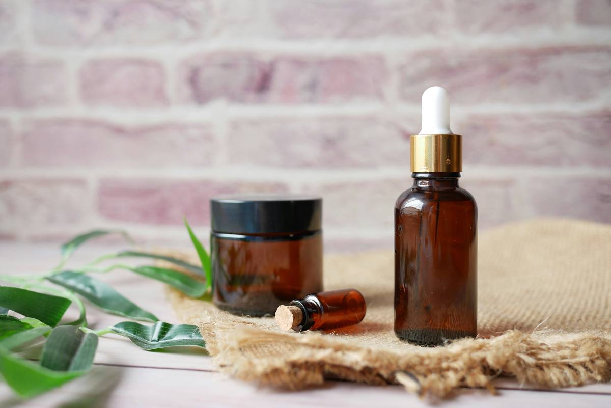 Bottle of aromatherapy oil skin care benefit oily blend with dropper on marble surface