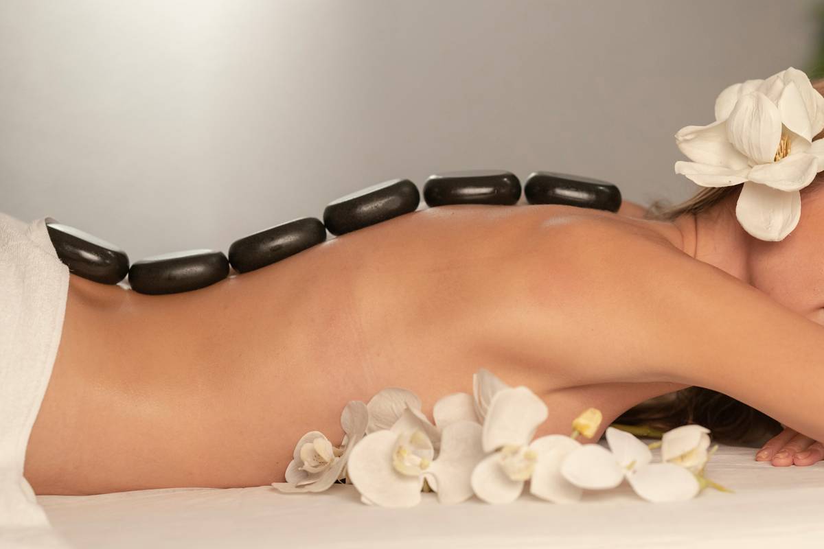 Woman applying specialist skincare body oil benefits to damp arms after shower